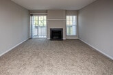 Located at 3399 Lakebrook Blvd in Knoxville, Tennessee, this single-floor residence offers a well-organized layout with a comfortable and functional design throughout. The kitchen serves as a highlight, outfitted with white shaker-style cabinetry, granite countertops, a stainless steel refrigerator, electric range, built-in microwave, and dishwasher, all illuminated by a skylight overhead. Wood-look flooring runs through the kitchen and entryway, adding warmth and durability to the high-traffic areas. A dedicated entry closet provides convenient storage near the front of the unit. The living area is generously sized with plush carpet and opens toward a fireplace framed by large windows and sliding glass doors that bring in natural light and outdoor views. The bedrooms continue the carpeted flooring and feature ample closet space, including a built-in closet system in one room. Multiple windows dressed with blinds allow for natural light while maintaining privacy. The bathroom is well-appointed with wood-look tile flooring, a white vanity with granite countertop, a full tub and shower combination with brushed nickel fixtures, and a large mirror. The overall interior palette of neutral tones throughout creates a clean, move-in-ready atmosphere.