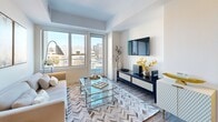 Located at 100 Steele St in Denver's sought-after Cherry Creek neighborhood, this thoughtfully designed single-floor residence offers a refined blend of modern finishes and functional living spaces. The open-concept kitchen is a standout feature, showcasing two-tone cabinetry with dark espresso lower cabinets and crisp white upper cabinets, white quartz countertops, a classic subway tile backsplash, stainless steel appliances including a gas range, and light wood-style flooring. A kitchen island with a stainless steel sink adds prep space and a casual seating option. The entryway is clean and welcoming, with light hardwood flooring that flows through the main living areas. The living room is bright and airy, benefiting from large windows that frame sweeping city views of Denver's skyline and surrounding urban landscape. Tray ceilings add architectural depth to both the living and bedroom spaces. The bedroom continues the theme of natural light with a large picture window offering additional city views. Two bathrooms serve the residence: one features a spacious vanity with dark cabinetry and large-format tile flooring, while the second includes a soaking tub and shower combination with neutral tile surround and mosaic accent detailing. Throughout, the space maintains a contemporary, cohesive aesthetic suited to modern urban living.