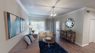 Located at 3601 Grapevine Mills Pkwy Frontage Rd in Grapevine, Texas, this single-floor residence offers a thoughtfully designed layout with contemporary finishes throughout. The living room serves as the centerpiece of the space, showcasing rich hardwood-style flooring, crown molding, and a striking orb chandelier that draws the eye upward. Large sliding glass doors flood the room with natural light and provide direct access to a private balcony with outdoor views. A decorative sideboard and sunburst mirror add refined character to the space.

The kitchen is well-equipped with white shaker-style cabinetry, granite countertops, a grey tile backsplash, and a full suite of stainless steel appliances, including a refrigerator, range, and microwave. A double undermount sink completes the functional and polished workspace.

The primary bedroom features plush carpeting, a ceiling fan with light fixture, a walk-in closet, and sliding glass door access to the balcony. The second bedroom also offers carpeted flooring, a walk-in closet, and tasteful wall accents. The bathroom includes granite-topped white vanity cabinetry, wood-look flooring, and a tiled shower area. A tiled entryway foyer provides a clean transition into the main living areas.