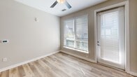 Located at 2420 N Brevard St in Charlotte's vibrant NoDa neighborhood, this 2-bedroom, 3-bathroom unit offers a thoughtfully designed, single-level layout. The open-concept kitchen and living area serves as the heart of the home, showcasing white shaker cabinetry, quartz countertops, a subway tile backsplash, and a full suite of stainless steel appliances including a refrigerator with ice maker, electric range, microwave, and dishwasher. A central island with pendant lighting adds both workspace and visual appeal, while light hardwood-style flooring ties the area together seamlessly. The living room benefits from abundant natural light through large windows and a glass exterior door, with a ceiling fan adding comfort. Both bedrooms are carpeted and feature windows with outdoor views, providing a quiet retreat. The primary bedroom includes direct access to a private bathroom and a walk-in closet with built-in shelving. The bathrooms are finished with white vanities, quartz countertops, large mirrors, and wood-look flooring. One bathroom features a soaking tub and shower combination. Two dedicated closets and in-unit laundry add practical convenience throughout this clean, modern residence.