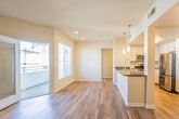 This well-appointed 3-bedroom, 2-bathroom residence at 700 Gibson Dr in Roseville, CA offers a thoughtfully designed single-floor layout. The spacious living room is a standout feature, boasting warm hardwood flooring, a classic fireplace with a built-in niche, and a glass door that opens to a private balcony, allowing natural light to fill the space. Recessed lighting and neutral-toned walls create a clean, inviting ambiance throughout.

The kitchen is outfitted with white shaker-style cabinetry, dark granite countertops, and a full suite of stainless steel appliances including a gas range, over-the-range microwave, dishwasher, and refrigerator. Hardwood flooring continues seamlessly from the open living and dining area into the kitchen.

Each of the three bedrooms features plush carpeting, mirrored sliding closet doors, and natural light from well-placed windows. The primary bedroom includes a ceiling fan for added comfort. Both bathrooms are finished with granite-topped white vanities and full tub-shower combinations with hardwood-style flooring. A dedicated in-unit laundry area houses a full-size washer and dryer, completing this functional and comfortable home.