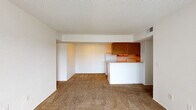 Located at Remington Drive in Dickson, Tennessee, this single-floor unit offers a practical and straightforward layout designed for comfortable everyday living. The open living and dining area is finished with neutral wall-to-wall carpeting and features a textured ceiling, creating a clean, bright atmosphere. A half-wall peninsula connects the living space to the galley-style kitchen, which is equipped with warm wood-toned upper cabinetry, white appliances including a refrigerator and electric range, a sink with lower cabinetry, and wood-look flooring that adds warmth to the space. Natural light flows into the living area through a full-width sliding glass door dressed with vertical blinds, providing direct access to an outdoor area. The bedrooms are carpeted and well-proportioned, each featuring textured ceilings and ample natural light from windows. At least one bedroom includes a closet with a classic six-panel double door. The unit includes two full bathrooms, both featuring a tub-shower combination, toilet, and vanity with sink. One bathroom features wood-look flooring and a wall-mounted towel bar, while the other mirrors a similar functional layout. Overall, the unit presents a clean, move-in ready interior with consistent finishes throughout.