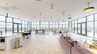 Located at 2801 E Main St in Richmond, Virginia, this expansive amenity lounge offers a sophisticated and well-appointed space designed for social gathering and relaxation. The open floor plan is bathed in natural light, courtesy of floor-to-ceiling black-framed windows that wrap around the perimeter, framing sweeping panoramic views of the Richmond skyline and the surrounding landscape below.

Large-format light tile flooring flows throughout the entire space, providing a clean, modern foundation. The lounge is thoughtfully organized into distinct functional zones. A billiards area anchors one section, highlighted by a rustic wood pool table set beneath a striking multi-arm sputnik chandelier and surrounded by generous windows with expansive outdoor views. Adjacent to this, a casual seating lounge features plush sofas, a fireplace set into a floor-to-ceiling textured tile accent wall, a wall-mounted television, and direct access to an outdoor terrace.

A separate conversation nook offers mid-century modern lounge chairs gathered around a sculptural wood coffee table, positioned to take full advantage of the views. The fully equipped kitchen features white cabinetry, a large central island with a quartz countertop, stainless steel appliances, and a bold cobalt blue tile backsplash that serves as a striking focal point. A dining area with a dark-toned table rounds out the space, making this lounge a complete and versatile retreat.