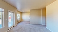 Located in Salem, Oregon, this single-floor, two-bedroom, two-bathroom residence offers a well-organized layout designed for comfortable everyday living. The living room greets you with warm, neutral tones, soft carpeting, and a window with an in-wall HVAC unit that allows natural light to fill the space. The transition between the living area and the combined kitchen and dining space is marked by a shift to wood-look plank flooring. The galley-style kitchen is efficiently designed with rich wood-toned cabinetry, white countertops, recessed lighting, and full appliances including a range, refrigerator, and over-the-range microwave. The primary bedroom is a generously sized retreat featuring carpet flooring, multiple windows for natural light, and a dedicated closet with built-in shelving. The second bedroom is comparably bright, also carpeted, with a window overlooking the exterior. Each bathroom offers distinct functionality: one features a full soaking tub with a shower surround and grab bar, while the other includes a glass-enclosed walk-in shower, a wood-toned vanity, and wood-look flooring. An in-unit laundry area houses a full-size washer and dryer with overhead shelving, adding everyday convenience. The utility room and two closets round out the practical offerings of this thoughtfully laid-out residence.