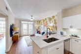 This one-bedroom, one-bathroom residence in Houston's Braeswood neighborhood offers a thoughtfully designed open-concept layout with modern finishes. The combined kitchen and living area serves as the heart of the home, anchored by a kitchen featuring white shaker cabinetry, subway tile backsplash, quartz countertops, a peninsula with bar seating, and a full suite of stainless steel appliances. The living area is bright and welcoming, highlighted by rich wood-look flooring, crown molding, a ceiling fan, and French doors that open to a private balcony with outdoor views. A dedicated pantry and in-unit laundry add everyday convenience. The bedroom is a comfortable retreat, adorned with a bold accent wall, large windows with outdoor views, and warm wood-look flooring. Three closets provide generous storage throughout the unit. The full bathroom includes a soaking tub with shower, a vanity with dark countertops, and wood-look flooring. A hallway connects the living spaces efficiently. The overall ambiance is bright, modern, and inviting, making this a well-rounded single-floor residence in a vibrant Houston community.