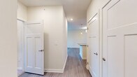 Located at 1000 Banner Dr in Gallatin, TN, this thoughtfully designed one-bedroom, one-bathroom residence offers a clean, modern aesthetic across a single floor. A welcoming hallway with wood-style flooring leads into the heart of the home, connecting the bedroom, bathroom, and closet to the main living areas.

The combined kitchen and living room serves as the central gathering space. The kitchen is outfitted with crisp white shaker cabinetry, dark granite countertops, a stainless steel sink, and a full suite of stainless steel appliances including a range, microwave, and refrigerator. A kitchen island with matching countertop adds functionality. Pendant lighting overhead enhances the bright, airy atmosphere. The living room flows naturally from the kitchen and features hardwood-style flooring, a ceiling fan, and a set of glass French doors that invite natural light and provide access to the outdoors.

The bedroom offers a comfortable and quiet retreat, finished with plush carpeting and neutral walls. A dedicated closet provides convenient storage. The bathroom is well-appointed with white shaker-style cabinetry, dark granite countertops, a single undermount sink, and a large vanity mirror framed by stylish lighting. Consistent hardwood-style flooring ties the bathroom to the rest of the home's cohesive design.