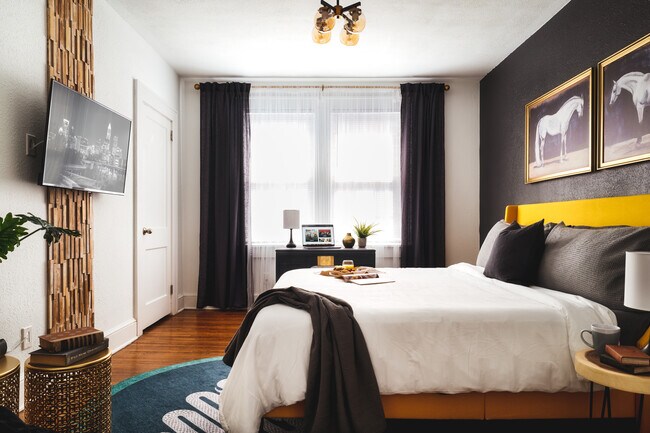 A sophisticated bedroom with bold contrasts, featuring sleek black and gold decor, soft lighting - 715 Grandin Rd