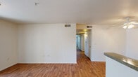This 2-bedroom, 2-bathroom unit at 1420 North Ave in Corcoran, CA offers a practical and comfortable single-floor layout. The combined kitchen and living area serves as the heart of the home, featuring warm wood-style flooring that extends throughout the main living spaces. The kitchen is equipped with oak-toned cabinetry offering generous storage, laminate countertops, a white refrigerator, a gas range, and a peninsula that provides additional counter space and separates the kitchen from the living area. The living room is bright and airy, highlighted by a sliding glass door that opens to a private balcony, allowing natural light to fill the space and providing outdoor access. Both bedrooms are carpeted and feature windows fitted with vertical blinds. The primary bedroom includes a sliding closet for storage. The two bathrooms are consistent in design, each featuring oak-style vanity cabinetry with laminate countertops, a wall-mounted mirror, and a tub-shower combination set on wood-style flooring. A hallway connects the bedrooms and bathrooms, and a dedicated closet provides additional storage. The unit's neutral color palette and clean finishes create a functional and move-in-ready living environment.