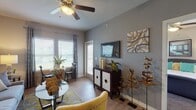 Located at City Base Landing in San Antonio, Texas, this single-floor residence offers a thoughtfully designed layout that balances comfort and modern style. The open-concept living and dining area is anchored by light wood-style flooring, neutral gray walls, and a ceiling fan overhead. Large windows allow generous natural light to fill the space, with a glass-top dining table positioned near a sliding door that provides outdoor access. The kitchen features dark cabinetry, granite-style countertops, a mosaic tile backsplash, and black appliances, including a refrigerator, range, and dishwasher. A peninsula counter adds additional workspace and visual separation from the living area. The bedroom is carpeted for warmth and comfort, with multiple windows, a ceiling fan, and direct access to a spacious walk-in closet with built-in shelving. The bathroom is finished with dark vanity cabinetry, granite-style countertops, wood-style flooring, and a shower-tub combination. Throughout the residence, consistent finishes and a cohesive neutral color palette create a polished, move-in-ready atmosphere suited for everyday living.