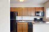 Located at 2619 Hydraulic Rd in Charlottesville, VA, this single-floor, 2-bedroom, 1-bathroom residence offers a practical and well-designed layout with a clean, neutral aesthetic throughout. The living room features light hardwood-style flooring, crown molding, and a large window with vertical blinds that fill the space with natural light and provide outdoor views. A ceiling fan adds a functional touch to this open, airy area. The kitchen is equipped with a gas range, over-the-range microwave, dark granite-style countertops, and warm wood cabinetry, complemented by a window that brings in additional natural light. Both bedrooms are carpeted in a neutral tone and include ceiling fans and windows with outdoor views, creating comfortable, well-lit retreats. The primary bedroom offers a generous footprint and access to a closet. The full bathroom features a clean, white tub-shower combination with brushed nickel fixtures. A hallway connects the main living areas efficiently. Throughout the home, consistent neutral wall tones, white trim, and clean finishes contribute to a cohesive, move-in-ready appearance.