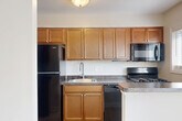 Located at 2619 Hydraulic Rd in Charlottesville, VA, this single-floor, 2-bedroom, 1-bathroom residence offers a practical and well-designed layout with a clean, neutral aesthetic throughout. The living room features light hardwood-style flooring, crown molding, and a large window with vertical blinds that fill the space with natural light and provide outdoor views. A ceiling fan adds a functional touch to this open, airy area. The kitchen is equipped with a gas range, over-the-range microwave, dark granite-style countertops, and warm wood cabinetry, complemented by a window that brings in additional natural light. Both bedrooms are carpeted in a neutral tone and include ceiling fans and windows with outdoor views, creating comfortable, well-lit retreats. The primary bedroom offers a generous footprint and access to a closet. The full bathroom features a clean, white tub-shower combination with brushed nickel fixtures. A hallway connects the main living areas efficiently. Throughout the home, consistent neutral wall tones, white trim, and clean finishes contribute to a cohesive, move-in-ready appearance.