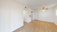 Located in Cutler Bay, FL, this one-bedroom, one-bathroom unit offers a well-organized single-floor layout designed to maximize functionality. Light wood-style flooring flows consistently throughout the space, complemented by crisp white walls and textured ceilings, creating a clean and cohesive aesthetic.

The living room is bright and open, featuring a ceiling fan with light fixture and a large sliding glass door that floods the space with natural light and provides direct access to the patio, which offers views of mature trees and the surrounding area. A second window further enhances ventilation and daylight.

The kitchen is equipped with dark gray cabinetry, white countertops, a single-basin sink, a dishwasher, and a refrigerator, offering efficient use of the available space. An adjacent utility area houses the electrical panel and additional storage.

The bedroom is a comfortable size, featuring a ceiling fan, a window with blinds for natural light and privacy, and a generous double-door closet for ample storage. A hallway connects the main living areas to the bathroom and provides access to a second closet.

The bathroom includes a combined tub and shower unit with built-in shelving, a vanity with white countertop, dark cabinetry, and gold-tone fixtures, maintaining a consistent design language throughout the unit.