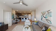 This single-story residence in Spring, Texas offers a thoughtfully designed open-concept floor plan with two bedrooms and two full bathrooms. The living area is anchored by light wood-look flooring, a ceiling fan, and large French doors that invite abundant natural light while providing access to an outdoor area. The space flows seamlessly into a dedicated dining area and an open kitchen, creating an ideal layout for entertaining.

The kitchen is a standout feature, showcasing dark taupe shaker-style cabinetry, a white quartz countertop, a central island with seating, subway tile backsplash, stainless steel appliances, and pendant lighting overhead. A dedicated laundry area with a full-size washer and dryer is conveniently accessible from the kitchen.

The primary bedroom is bright and comfortable, with plush carpeting, multiple windows, and a ceiling fan. It connects directly to a private en-suite bathroom featuring granite countertops, dark cabinetry, a large vanity mirror, and a walk-in closet. The second bedroom is equally well-lit with natural light and is served by a second full bathroom that mirrors the same refined finishes. Throughout, the neutral color palette and consistent design elements create a cohesive and welcoming ambiance.