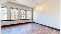 Situated in the heart of downtown Dallas at 1509 Main Street, this single-floor urban residence combines modern finishes with a classic city-building character. The open living area features rich hardwood-style flooring, crisp white walls, and a bank of large, dark-trimmed windows that frame striking views of Dallas's historic downtown architecture, filling the space with abundant natural light. Track lighting mounted to an exposed ceiling adds an industrial touch to the airy atmosphere.

The kitchen is a standout feature, boasting soaring ceilings, pendant lighting, and a full suite of stainless steel appliances including a French door refrigerator, electric range, microwave, and dishwasher. Dark espresso cabinetry pairs cleanly with white tile backsplash and light countertops, delivering a sleek, contemporary aesthetic.

The two bathrooms are finished consistently with dark wood cabinetry. One features a tub-shower combination with a bold checkered tile surround and warm wood-tone flooring, while the second offers a vanity with a large mirror and marble-style tile flooring. A dedicated laundry room with a full-size washer and dryer adds everyday convenience. The overall ambiance is modern urban living with a nod to downtown Dallas's architectural heritage.