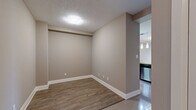 Located at 15 Maple Ave, Suite 610 in Barrie, Ontario, this well-appointed one-bedroom, two-bathroom unit offers a thoughtfully designed single-floor layout. The open-concept kitchen and living area forms the heart of the unit, featuring rich dark-stained cabinetry, stainless steel appliances, a stylish tile backsplash, and a stone-topped peninsula with pendant lighting overhead — ideal for both cooking and casual dining. The living room extends naturally from the kitchen, finished with light hardwood-style flooring, neutral warm-toned walls, and a sliding glass door that opens onto a private balcony, allowing natural light to fill the space. The spacious primary bedroom is finished with plush carpeting, large windows with blinds, and direct access to the en-suite bathroom. The main bathroom features crisp white subway tile, a soaker tub, and a glass shower partition, while the second bathroom offers a clean, minimalist design with a pedestal sink. A dedicated hallway with a closet provides practical storage. Throughout the unit, neutral tones and contemporary finishes create a cohesive, modern ambiance well-suited for comfortable everyday living.
