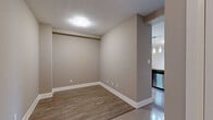 Located at 15 Maple Ave, Suite 610 in Barrie, Ontario, this well-appointed one-bedroom, two-bathroom unit offers a thoughtfully designed single-floor layout. The open-concept kitchen and living area forms the heart of the unit, featuring rich dark-stained cabinetry, stainless steel appliances, a stylish tile backsplash, and a stone-topped peninsula with pendant lighting overhead — ideal for both cooking and casual dining. The living room extends naturally from the kitchen, finished with light hardwood-style flooring, neutral warm-toned walls, and a sliding glass door that opens onto a private balcony, allowing natural light to fill the space. The spacious primary bedroom is finished with plush carpeting, large windows with blinds, and direct access to the en-suite bathroom. The main bathroom features crisp white subway tile, a soaker tub, and a glass shower partition, while the second bathroom offers a clean, minimalist design with a pedestal sink. A dedicated hallway with a closet provides practical storage. Throughout the unit, neutral tones and contemporary finishes create a cohesive, modern ambiance well-suited for comfortable everyday living.