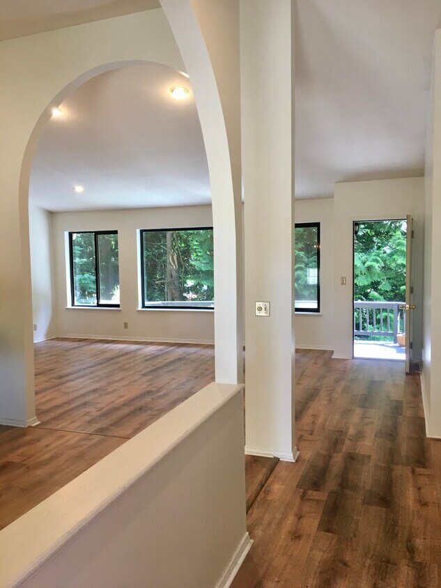 Sala de estar y comedor de concepto abierto con pisos LVP que se abren a la terraza y al patio trasero. - 840 Cherry Ave NE