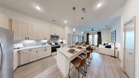 Located at 5885 Calmont Ave in Fort Worth, TX, this well-appointed 2-bedroom, 2-bathroom single-story home offers a thoughtfully designed open-concept layout with modern finishes throughout. The combined living, dining, and kitchen area serves as the heart of the home, featuring light wood-tone cabinetry, granite countertops, stainless steel appliances, and a large center island with seating — ideal for both everyday living and entertaining. Wide-plank hardwood-style flooring flows through the main living areas, while the living room benefits from large patio-facing windows and a ceiling fan that fill the space with natural light. The primary bedroom is generously sized, outfitted with plush carpeting and direct access to a private en-suite bathroom complete with a glass-enclosed shower, granite vanity, and wood-tone cabinetry. A spacious walk-in closet with built-in shelving adds abundant storage. The second bedroom is equally well-finished with its own adjacent bathroom. Five closets, a dedicated laundry area, a pantry, and three patio spaces round out the functional offerings of this home, delivering a comfortable and well-organized living experience.