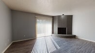 Located at 5470 N Meridian Ave in Oklahoma City, Oklahoma, this single-story home presents a thoughtfully laid-out floor plan with consistent modern finishes throughout. The living area serves as a central gathering space, highlighted by a striking floor-to-ceiling corner brick fireplace with a raised hearth, adding architectural character and warmth to the room. Gray-toned vinyl plank flooring runs throughout the home, providing a cohesive and contemporary aesthetic. A large sliding glass door fitted with vertical blinds floods the living space with natural light while offering access to the outdoors.

The bedrooms feature the same durable vinyl plank flooring and are brightened by arched windows that lend a classic architectural touch, along with additional standard windows that maximize natural illumination. The neutral gray wall tones complement the flooring throughout.

The bathroom includes a speckled countertop vanity and a full tub-shower combination with white tile surround, offering functional, clean design. Textured ceilings are present throughout the home. The overall layout, as indicated by the dollhouse view, connects living, kitchen, bedroom, and bathroom areas in a practical, single-level arrangement suited for comfortable everyday living.