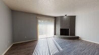 Located at 5470 N Meridian Ave in Oklahoma City, Oklahoma, this single-story home presents a thoughtfully laid-out floor plan with consistent modern finishes throughout. The living area serves as a central gathering space, highlighted by a striking floor-to-ceiling corner brick fireplace with a raised hearth, adding architectural character and warmth to the room. Gray-toned vinyl plank flooring runs throughout the home, providing a cohesive and contemporary aesthetic. A large sliding glass door fitted with vertical blinds floods the living space with natural light while offering access to the outdoors.

The bedrooms feature the same durable vinyl plank flooring and are brightened by arched windows that lend a classic architectural touch, along with additional standard windows that maximize natural illumination. The neutral gray wall tones complement the flooring throughout.

The bathroom includes a speckled countertop vanity and a full tub-shower combination with white tile surround, offering functional, clean design. Textured ceilings are present throughout the home. The overall layout, as indicated by the dollhouse view, connects living, kitchen, bedroom, and bathroom areas in a practical, single-level arrangement suited for comfortable everyday living.