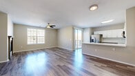 Located at 1921 Denver West Ct in Lakewood, Colorado, this two-floor residence offers a thoughtfully designed open-concept layout that promotes a bright, airy atmosphere throughout. The main living area features smooth hardwood-style flooring and a ceiling fan, with natural light streaming in through large windows and a sliding glass door that opens to a private balcony. From the balcony, residents enjoy direct views of the Colorado foothills, providing a striking natural backdrop.

The kitchen is a standout feature, outfitted with two-tone cabinetry — white upper cabinets paired with grey lower cabinets — white quartz countertops, a stainless steel appliance suite including a refrigerator with ice and water dispenser, range, microwave, and dishwasher. A peninsula with an integrated sink adds functional workspace and connects the kitchen seamlessly to the living area.

Bedroom spaces are carpeted for comfort, with ceiling fans and windows that allow ample natural light. The primary bedroom connects to a generously sized walk-in closet, fully lined with built-in shelving and hanging rods. The bathroom includes a soaking tub with white tile surround. Additional rooms feature hardwood-style flooring and well-proportioned layouts across both floors.