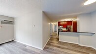 Located at 8209 College Trail in Inver Grove Heights, MN, this single-floor home offers four bedrooms and one bathroom across a well-organized layout. Light-toned hardwood-style flooring runs throughout the entire space, creating a cohesive and clean aesthetic from room to room.

The combined kitchen and living area serves as the heart of the home. The kitchen is outfitted with rich, deep-toned cabinetry, granite-style countertops, stainless steel appliances including a refrigerator and range, a built-in dishwasher, and a peninsula with a sink — all illuminated by track lighting overhead. A textured ceiling adds character throughout the common areas.

The four bedrooms are well-proportioned, with the primary bedroom offering generous space. Each bedroom features neutral warm-toned walls and ceiling fans where applicable, with select rooms benefiting from natural light through blinds-equipped windows and baseboard heating for year-round comfort.

The bathroom includes a granite-topped vanity with a single sink, a mirror, and a shower/tub combination. Notably, an in-unit washer is conveniently located within the bathroom area. A hallway connects the bedrooms and common areas, providing a practical and efficient flow throughout the home.