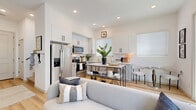Located in Casa Grande, AZ, this thoughtfully designed two-story home offers a seamless blend of modern style and functional living across two floors. The main level features an open-concept layout that connects the living room, dining area, and kitchen in one cohesive space. The kitchen is appointed with crisp white shaker cabinetry, stainless steel appliances including a refrigerator with ice maker and a dishwasher, a marble-topped island with bar seating, and light hardwood flooring that extends throughout the main level. Natural light pours in through multiple windows dressed with clean white blinds. The living room is bright and welcoming, with high clerestory windows, a ceiling fan, and ample space for comfortable seating. A dedicated entrance, hallway, and conveniently located laundry closet with full-size washer and dryer complete the main floor. Upstairs, the private bedroom retreat features plush carpeting, a ceiling fan, generous closet space, and direct access to a well-appointed en-suite bathroom with a glass-enclosed walk-in shower and wood-toned accents. A second full bathroom serves the home as well. Three closets throughout the home ensure abundant storage. The overall ambiance is clean, contemporary, and move-in ready.
