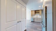 Located in the heart of downtown Los Angeles, this thoughtfully designed two-bedroom, two-bathroom residence offers a clean, modern aesthetic throughout its well-appointed single floor. Wide-plank hardwood flooring flows seamlessly through the living spaces, complementing the bright, neutral palette that defines the home's contemporary character.

The kitchen is a standout feature, outfitted with light wood cabinetry, gold-toned hardware, a textured tile backsplash, and a full suite of stainless steel appliances including a gas range, built-in microwave, dishwasher, and French door refrigerator. Ample upper and lower cabinetry, including open shelving, provides generous storage.

The bedrooms are bathed in natural light through large picture windows that frame views of the surrounding Los Angeles cityscape. The generously sized primary bedroom connects directly to its own bathroom and features a dedicated walk-in closet with built-in shelving and double hanging rods. The bathrooms are finished with large-format tile, a soaking tub with tiled surround, and wood-toned vanity cabinetry with light stone countertops.

Two closets throughout the unit ensure practical storage, while recessed lighting and clean white walls create a bright, move-in-ready environment ideal for urban living.