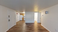 This single-floor residential unit offers a clean, functional layout designed for practical everyday living. The open main living area is finished with wood-look plank flooring and neutral white walls, creating a bright and versatile space. A textured ceiling and baseboard heating run throughout, providing consistent comfort year-round.

The kitchen is efficiently arranged and equipped with warm honey-toned wood cabinetry, ample upper and lower storage, granite-look countertops, a stainless steel sink, a white refrigerator, a white range, and a dishwasher — offering everything needed for everyday meal preparation.

Two bedrooms provide comfortable retreats, each featuring soft carpeting, baseboard heating, and wall-unit air conditioning. Natural light enters through sizable windows fitted with blinds, with one bedroom offering a pleasant outdoor green view. Each bedroom also includes closet storage.

The unit features two bathrooms. The first is a bright, compact full bath with a tub/shower combination, wood-look flooring, and a window for ventilation. The second is a clean, updated bathroom featuring a white vanity with cabinet storage, a framed mirror with overhead lighting, and wood-look flooring. The overall ambiance is tidy, neutral, and move-in ready.
