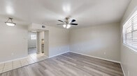 This well-appointed one-bedroom, one-bathroom unit in Baton Rouge, Louisiana offers a practical and comfortable layout across a single floor. The living room welcomes you with neutral-toned walls, wood-look laminate flooring, and a ceiling fan with integrated lighting, creating a bright and airy atmosphere. Natural light filters in through the windows, enhancing the clean, open feel of the space. The galley-style kitchen is thoughtfully designed with white cabinetry featuring matte black hardware, granite-look countertops, and tile flooring, providing ample workspace and storage while maintaining a modern aesthetic. The bedroom is a comfortable retreat, featuring the same wood-look flooring, a ceiling fan, a window for natural light, and direct access to a spacious walk-in closet with built-in shelving — a standout feature that adds excellent storage capacity. The full bathroom is finished with tile flooring, a granite-topped vanity with grey cabinetry, and a tub-shower combination with brushed nickel fixtures. Throughout the unit, a consistent neutral color palette and clean finishes create a cohesive and move-in-ready environment suited for comfortable everyday living in Baton Rouge.