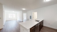 Located at 225 Bay 401 in Jersey City, NJ, this modern single-floor residence offers a thoughtfully designed open-concept layout with clean finishes throughout. The kitchen serves as a central hub, featuring a large island with a white quartz countertop, an undermount sink, and rich dark-wood cabinetry. Stainless steel appliances — including a gas range, over-the-range microwave, refrigerator, and dishwasher — complement a mosaic tile backsplash that adds a stylish accent. Hardwood-style flooring flows seamlessly throughout the main living areas and bedrooms, lending warmth and continuity to the space. The open living area is generously proportioned, bathed in natural light from large windows that frame views of the surrounding urban streetscape. A dedicated in-unit laundry closet with a stacked washer and dryer adds everyday convenience. The bathrooms are finished with subway tile surrounds featuring a decorative mosaic border, dark-wood vanities with white quartz countertops, undermount sinks, and a soaking tub. The bedrooms are bright and airy, each with large windows inviting ample sunlight. Crisp white walls and clean architectural lines throughout create a contemporary, move-in-ready atmosphere in the heart of Jersey City.