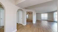Located at 888 E Clinton St in Phoenix, Arizona, this single-story 2-bedroom, 3-bathroom home offers a well-organized layout with a thoughtful mix of materials and finishes throughout. The open living area features light wood-style flooring, a textured ceiling, and large sliding glass doors that invite natural light and provide outdoor access. An arched architectural detail adds character to the transition between living spaces. The kitchen connects seamlessly to the living area via a pass-through counter, and is equipped with gray cabinetry, a stainless steel refrigerator, black appliances including a range and microwave, and a double sink. The primary bedroom is generously sized, with plush carpeting, a ceiling fan, and multiple windows fitted with vertical blinds that allow ample natural light. It is complemented by a dedicated bathroom featuring a dual-sink vanity with wood-tone cabinetry and a skylight overhead. The second bedroom also features carpet flooring and a sliding closet. Additional bathrooms include a full tub/shower combo with white tile surround. A separate hallway closet with built-in rod storage adds practical storage. The neutral color palette and clean finishes create a bright, functional living environment throughout.