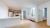 Located at 1001 W Elizabeth Ave in Linden, NJ, this 2-bedroom, 2-bathroom residence offers a thoughtfully designed single-floor layout with modern finishes throughout. Light wood-tone flooring flows seamlessly across all rooms, complemented by clean white walls and trim that create a bright, cohesive aesthetic.

The open-concept living, dining, and kitchen area forms the heart of the unit. The kitchen is equipped with stainless steel appliances — including a refrigerator, electric range, and over-the-range microwave — paired with taupe shaker-style cabinetry, white subway tile backsplash, and a white countertop island. Large windows invite natural light into the living and dining space, which also features a wall-mounted HVAC unit.

Both bedrooms are generously proportioned with neutral gray walls, large windows, and wood-tone flooring. The primary bedroom includes two closets, offering ample storage. The second bedroom is equally well-lit and comfortable.

The two bathrooms each feature wood-tone flooring and clean white finishes. One bathroom includes a glass-enclosed walk-in shower with tiled walls, while the second offers a full tub-shower combination. Additional highlights include four closets throughout, a dedicated laundry area, and a welcoming entrance — making this a highly functional and move-in ready residence.