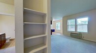 This well-designed apartment offers 900 square feet of living space on a single floor. The layout includes two bedrooms, one bathroom, and an open-concept living area that combines the kitchen and living room. The primary bedroom is generously sized at 200 square feet, providing ample space for relaxation and storage.

The living room is the heart of the home, featuring a modern fireplace with a white mantel, adding both warmth and visual interest. Large windows allow natural light to flood the space, while plush carpeting enhances comfort. The kitchen boasts contemporary wood cabinetry, granite countertops, and stainless steel appliances, including a refrigerator, stove, and built-in microwave. Durable wood-look flooring in the kitchen area adds a touch of elegance and easy maintenance.

Both bedrooms are carpeted and offer good-sized windows for natural illumination. The bathroom features a practical tub-shower combination with modern fixtures. Throughout the apartment, neutral-toned walls provide a blank canvas for personal decor. Climate control is ensured with a wall-mounted air conditioning unit, ensuring year-round comfort in this well-appointed Vancouver, WA residence.