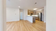 Located at 116 Meadows Dr in Piscataway, NJ, this well-appointed 2-bedroom, 3-bathroom residence offers a thoughtfully designed single-floor layout. The open-concept living and kitchen area serves as the heart of the home, featuring light hardwood-style flooring that extends throughout the main living spaces, creating a bright and cohesive feel. The kitchen is outfitted with modern taupe shaker-style cabinetry, a stainless steel refrigerator, gas range, and built-in microwave, complemented by light quartz countertops and a peninsula that provides additional prep and seating space. The living area flows naturally from the kitchen, offering an open and airy atmosphere with clean white walls and recessed lighting. Both bedrooms are carpeted for comfort, with the generously sized primary bedroom featuring a walk-in closet equipped with wire shelving. Natural light enters through windows with blinds in the secondary bedroom. All three bathrooms are finished with marble-style tile flooring and warm wood vanities topped with white countertops, maintaining a clean and contemporary aesthetic throughout. The overall design emphasizes a modern, neutral palette with quality finishes, making this a functional and inviting space.