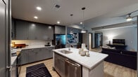 Located at 417 W Peace St in Raleigh, NC, this contemporary single-floor residence offers a thoughtfully designed open-concept layout with modern finishes throughout. The kitchen serves as a central showpiece, featuring gray shaker-style cabinetry, quartz countertops with a white marble-like finish, a large center island with a built-in sink and stainless steel dishwasher, and a full suite of stainless steel appliances including a French door refrigerator, electric range with microwave, and white subway tile backsplash. Warm wood-tone flooring flows consistently throughout the space, enhancing the cohesive aesthetic. The living room makes a bold statement with a dramatic deep navy accent wall, floor-to-ceiling windows that invite abundant natural light, and direct access to an outdoor balcony with city views. The primary bedroom is elegantly appointed with arched wall mirrors and warm, neutral tones, while a secondary bedroom features a ceiling fan and window with exterior views. Two full bathrooms complete the layout — one with a soaking tub and tiled surround, the other with a glass-enclosed walk-in shower — both showcasing gray vanities with quartz countertops and wood-look tile flooring. This residence combines modern urban design with functional, refined living spaces.