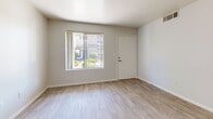 Located at 5060 W Hacienda Ave in Las Vegas, NV, this one-bedroom, one-bathroom unit offers a well-designed single-floor layout with a clean, modern aesthetic. Light wood-look flooring runs throughout, complementing the bright, neutral color palette that gives the space an open and airy feel.

The combined kitchen and living area serves as the heart of the unit. The kitchen is outfitted with white shaker-style cabinetry, stone-look countertops, a dark subway tile backsplash, and a full suite of stainless steel appliances including a gas range, microwave, dishwasher, and refrigerator. A peninsula with an undermount sink and a gooseneck faucet provides additional prep space and a natural divide between the kitchen and living area. A skylight above the kitchen enhances brightness.

The living area is open and well-lit, with a large window offering views of the surrounding landscaping. The bedroom is a comfortable size, featuring a ceiling fan with light fixture, a large sliding-door closet offering generous storage, and a sizable window that brings in natural light. The bathroom maintains the same clean design language with white cabinetry, stone-look countertops, a tiled tub-shower combo, and wood-look flooring.