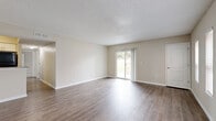 Located at 1763 Main St in Dunedin, FL, this single-story, 2-bedroom, 2-bathroom home offers a practical and comfortable layout with clean, neutral finishes throughout. The open living area is bathed in natural light, courtesy of a full sliding glass door that frames outdoor views and provides easy access to the exterior. Wood-look luxury vinyl flooring flows throughout the main living spaces, complemented by crisp white baseboards and a textured ceiling.

The kitchen is thoughtfully appointed with granite countertops, dark cabinetry contrasted by white upper cabinets, a decorative mosaic tile backsplash, a stainless steel sink, and black appliances including a refrigerator, range, and dishwasher. Both bedrooms feature soft wall-to-wall carpeting and multiple windows fitted with blinds that allow for an abundance of natural light. The spacious primary bedroom includes a closet with classic louvered bifold doors. Each bathroom is finished with granite-top dark vanities and wood-look vinyl flooring; one bathroom offers a walk-in glass shower, while the other features a shower/tub combo with grab bars. The home's warm, neutral color palette and updated finishes create a clean, move-in-ready atmosphere throughout.