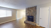 Located at 2021 Highridge Dr SW in Huntsville, Alabama, this single-floor home offers a practical and comfortable layout throughout. The living area serves as the centerpiece of the home, highlighted by a dramatic floor-to-ceiling natural stone fireplace with a raised hearth that adds warmth and character to the space. Wood-style hard flooring runs through the main living areas, complemented by neutral gray walls and a textured ceiling. Vertical blinds cover a sliding door, allowing for controlled natural light.

The kitchen features white cabinetry with ample storage, dark granite-style countertops, a double-basin sink, and wood-style flooring that ties seamlessly into the adjoining areas. The bedrooms are carpeted for comfort and each includes a ceiling fan with light fixture. The primary bedroom benefits from direct access to a dedicated bathroom, as well as an additional closet for generous storage.

The bathrooms are well-appointed with tub-shower combinations, granite-style vanity countertops, and textured ceilings consistent with the rest of the home. Each bathroom is clean and functional in design. Overall, the home presents a cohesive neutral palette, practical finishes, and a well-organized single-level floor plan suited for everyday living.
