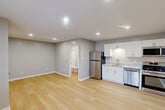 Located at 211 Swan Dr in Athens, Alabama, this single-level studio unit offers a well-organized and thoughtfully designed living space. Light luxury vinyl plank flooring runs throughout, contributing to a clean, cohesive aesthetic enhanced by neutral gray walls and bright white trim.

The open main area seamlessly integrates the living space and kitchen, making efficient use of the available square footage. The kitchen is outfitted with white shaker-style cabinetry, granite-look countertops, a stainless steel sink, and a full suite of stainless steel appliances including a refrigerator, gas range, over-the-range microwave, and dishwasher. Recessed lighting illuminates the kitchen area effectively.

The main living area features a wall-mounted HVAC unit and a window with blinds that allows for natural light and outdoor views. A dedicated entry door with an adjacent window provides an inviting point of entry. The textured ceiling and recessed lighting throughout add a finished, polished feel to the space.

A closet offers practical storage, while the full bathroom includes a tub/shower combination with a curtain rod, toilet, and towel bar, finished in neutral tones. This unit combines modern, updated finishes with functional design for comfortable everyday living.