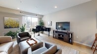 This single-floor residence at 4027 CR-25 in St. Louis Park, Minnesota, presents a thoughtfully designed layout with contemporary finishes throughout. The open-concept living area features light hardwood flooring, recessed lighting, and large sliding glass doors that invite natural light and offer views of the surrounding neighborhood. The space is versatile enough to accommodate a grand piano alongside comfortable seating, demonstrating its generous proportions.

The adjacent sitting room provides a more intimate setting, with soft neutral tones and a built-in niche adding architectural interest. A dedicated workspace area offers a clean, minimalist setup with warm accent lighting.

The kitchen is outfitted with dark wood cabinetry extending to the ceiling, white quartz countertops, a subway tile backsplash, and a full suite of stainless steel appliances, including a gas range and built-in microwave. Light hardwood flooring continues throughout.

The bedrooms are calm and understated, with neutral carpeting and large windows framing outdoor views. The primary bedroom benefits from a ceiling fan and generous natural light.

The bathrooms are finished with large-format porcelain tile flooring and dark wood vanities. One features a tub-shower combination with classic white subway tile, while others offer refined, efficient layouts with clean white fixtures.