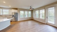 Located in Oviedo, FL, this well-appointed 2-bedroom, 3-bathroom single-floor residence offers a thoughtfully designed layout with modern finishes throughout. The open-concept kitchen and living area serves as the heart of the home, featuring white shaker-style cabinetry, a subway tile backsplash, white quartz countertops, stainless steel appliances, and a distinctive curved center island — all set atop light-toned luxury vinyl plank flooring. Large windows in the adjacent living area invite generous natural light and views of surrounding greenery, complemented by a ceiling fan overhead. The primary bedroom is a spacious retreat with soft carpeting, multiple windows with lush outdoor views, and a ceiling fan. Its en-suite bathroom includes a white quartz vanity, wood-framed mirror, walk-in glass shower, and direct access to a dedicated closet with built-in shelving. The second bedroom also features plush carpet, natural light from dual windows, and ceiling fan, with a connected full bathroom offering a soaking tub and tiled surround. A third full bathroom, hallway, entrance, and closet round out the functional and cohesive floor plan of this clean, contemporary residence.
