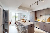 Located in Coral Springs, Florida, this well-appointed 3-bedroom, 2-bathroom residence offers a thoughtfully designed single-floor layout that maximizes both functionality and style. The open-concept kitchen serves as the heart of the home, featuring dark wood-grain cabinetry, white quartz countertops, a subway tile backsplash, stainless steel appliances, and a central island with bar seating — ideal for cooking and casual dining. Track lighting overhead adds a modern, polished touch. The kitchen flows seamlessly into the living area, which is bathed in natural light from large sliding glass doors that open to an outdoor balcony with green views beyond. The primary bedroom offers a comfortable and serene retreat, while the additional bedrooms provide flexible space for family or guests. Both bathrooms are finished with marble-look tile surrounds, white cabinetry, and stone-topped vanities — one featuring a walk-in shower and the other a full soaking tub. Throughout the residence, light-toned flooring, clean white walls, and recessed lighting create a bright, contemporary ambiance. A dedicated closet provides added storage convenience, rounding out this well-equipped and modern Coral Springs home.