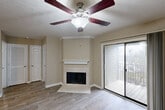 Located at 3900 Crosby Dr in Lexington, Kentucky, this one-bedroom, one-bathroom residence offers a well-organized layout designed for comfortable everyday living. The living room serves as the heart of the home, highlighted by a corner fireplace with a classic white mantel, crown molding, and a ceiling fan with a built-in light fixture. Sliding glass doors flood the space with natural light and open directly onto a private balcony, providing a seamless indoor-outdoor connection. Wood-style flooring runs throughout the main living areas, lending a clean and cohesive aesthetic. The galley-style kitchen is thoughtfully appointed with rich dark cabinetry, granite-style countertops, stainless steel appliances including a refrigerator and microwave, and ample storage on both sides. The bedroom is a generously sized retreat featuring soft carpet, multiple windows with blinds that invite natural light, and a dedicated closet. The full bathroom is well-equipped with dark vanity cabinetry, granite-style countertops, a lighted mirror, and a tub-shower combination. Neutral warm tones throughout the space create a welcoming and versatile atmosphere suited to a variety of personal styles.