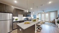 Located at 15915 Kingfield Dr in Houston, TX, this well-appointed one-bedroom, one-bathroom residence offers a thoughtfully designed open-concept floor plan across a single level. The living and kitchen areas flow seamlessly together, anchored by warm wood-look flooring and a ceiling fan that enhances airflow and comfort. Large sliding glass doors in the living room invite abundant natural light and provide an easy connection to the outdoors.

The kitchen is a standout feature, showcasing dark espresso cabinetry, granite countertops, a spacious center island with bar seating, and a full suite of stainless steel appliances. Stylish pendant lighting suspended above the island adds both functionality and a modern aesthetic touch.

The bedroom is a comfortable retreat, finished with the same wood-look flooring and neutral tones, with access to a walk-in closet outfitted with multi-tier wire shelving for generous storage. The full bathroom features granite countertops, dark cabinetry that mirrors the kitchen, and a soaking tub-shower combination with tile surround. A dedicated laundry area provides added convenience. The overall ambiance is clean, contemporary, and cohesive throughout.