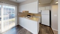 Located at 2095 Valley Greene Dr in Dayton, Ohio, this two-story home offers a clean, functional layout designed for comfortable everyday living. The kitchen serves as a practical hub of the main floor, featuring white cabinetry that extends to the ceiling for generous storage, light-toned countertops, a peninsula with a coil-top range, a sink, and a full-size refrigerator. Durable wood-look flooring runs throughout the kitchen and connects seamlessly to the adjacent areas, while a sliding glass door provides access to the outdoors and fills the space with natural light. A half bathroom on the main level includes a white vanity and wood-look flooring, adding convenience for guests. The upper floor hosts multiple well-proportioned bedrooms, each finished with neutral-toned carpet and walls that create a calm, versatile atmosphere. Windows in each bedroom allow natural light to filter in, offering views of the surrounding neighborhood. The primary bedroom features direct access to a dedicated bathroom and a closet, enhancing its functionality. Full bathrooms are finished with white tub-shower surrounds, wood-look flooring, and white vanities, maintaining a consistent, clean aesthetic throughout. Staircase access connects both floors, contributing to the home's efficient and straightforward design.