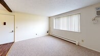 Located at 10 Taylor St in Franklin, Pennsylvania, this single-floor unit offers a practical and well-organized layout designed for comfortable everyday living. The kitchen is a functional highlight of the space, featuring rich dark wood cabinetry, hardwood-style flooring, and a full suite of white appliances including a gas range, microwave, dishwasher, and refrigerator. Ample counter space and a built-in sink make this an efficient area for meal preparation.

The living areas and bedrooms are finished with neutral-toned carpet throughout, providing a warm and quiet underfoot feel. Each room is equipped with baseboard heating units, ensuring consistent warmth during cooler months. Windows fitted with blinds are present in multiple rooms, allowing for adjustable natural light and views of the surrounding greenery and outdoor landscape.

One of the bedrooms features a ceiling fan, adding to the comfort of the space, while another includes a sliding closet for built-in storage. The clean, white walls throughout the unit create a bright and versatile backdrop that adapts easily to various furnishing styles. The overall ambiance is calm and understated, with a no-frills design that prioritizes functionality and livability.