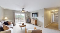 Located at 1825 E Republic Rd in Springfield, MO, this well-appointed single-story home offers three bedrooms, two bathrooms, and three closets across a comfortable and efficiently designed floor plan. The living room sets a welcoming tone with soft neutral walls, plush carpeting, and a ceiling fan overhead, creating a relaxed and functional gathering space. The galley-style kitchen is outfitted with light wood cabinetry, dark granite countertops, hardwood flooring, and black appliances, providing ample storage and workspace. The primary bedroom features a walk-in closet and ceiling fan, offering a practical and restful retreat. Two additional bedrooms each include ceiling fans and windows that allow natural light to filter in, providing comfortable and versatile spaces. Both bathrooms are finished with hardwood floors, warm wood vanity cabinetry, and dark granite countertops, with shower and tub combinations enclosed by curtains. Ceiling fans are present throughout the home, contributing to consistent comfort year-round. The overall aesthetic is cohesive and neutral, with soft gray and beige tones that create a calm, move-in-ready atmosphere suitable for a variety of lifestyles.