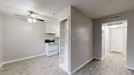 Located at 208 NW 54th Dr in Oklahoma City, OK, this single-story, two-bedroom, one-bathroom unit offers a functional and well-appointed layout. The combined kitchen and living area serves as the heart of the home, featuring light wood-style flooring, neutral gray walls, a textured ceiling, and a ceiling fan with light fixture. A built-in shelving unit provides a convenient divider between spaces. The kitchen is efficiently designed in a U-shape, outfitted with white cabinetry, granite-style countertops, open display shelving, a range with an overhead exhaust hood, and a full-size refrigerator. The bathroom continues the granite-style countertop theme, paired with white vanity cabinetry, a framed mirror, and wood-style flooring extending into the space. Both bedrooms are carpeted for comfort. The primary bedroom features a ceiling fan, a window with blinds allowing natural light, and painted cinder block accent walls that lend a distinctive character. Closet storage is well-provided, with one bedroom showcasing dual closets. The second bedroom is bright and open, with neutral walls and carpet. Throughout the unit, consistent finishes and clean lines create a cohesive, move-in ready environment.