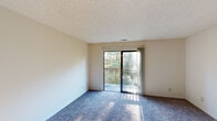 Located at 540 Anchor Dr in Cincinnati, Ohio, this single-floor unit offers a straightforward and functional layout across several well-defined spaces. The living area is generously sized, finished with blue-gray carpeting that extends throughout most of the unit, and features a sliding glass door that opens onto a private balcony overlooking a lush, wooded backdrop—bringing in natural light and pleasant outdoor views.

The kitchen is distinguished by warm hardwood-style flooring, white cabinetry, a coil-top electric range, and a built-in sink with countertop workspace. A ceiling fan overhead adds comfort and practicality to the space. The kitchen connects naturally to the main living area, supporting an open and accessible flow.

The bedrooms are carpeted and bright, each benefiting from windows that frame views of surrounding greenery. One bedroom includes a sliding wood-panel closet door offering convenient built-in storage. Textured popcorn ceilings are consistent throughout the unit, and neutral wall tones provide a clean, adaptable canvas. The overall layout, as shown in the floor plan, is compact yet efficiently organized, making practical use of the available space.